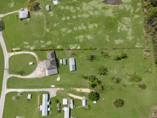 a view of a house with a big yard and large trees