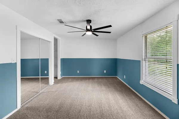 a view of a livingroom with a ceiling fan and window