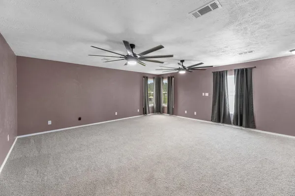 a view of an empty room with a ceiling fan