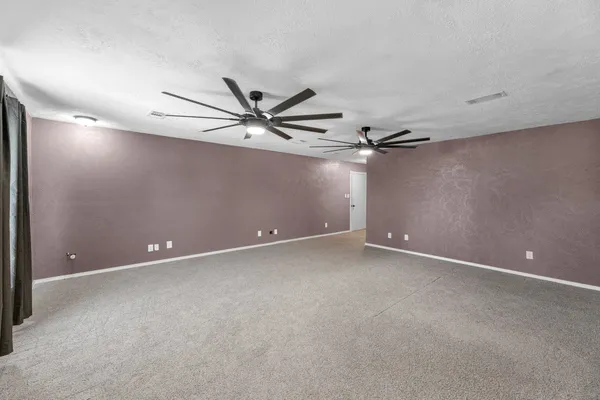 an empty room with a ceiling fan and a window