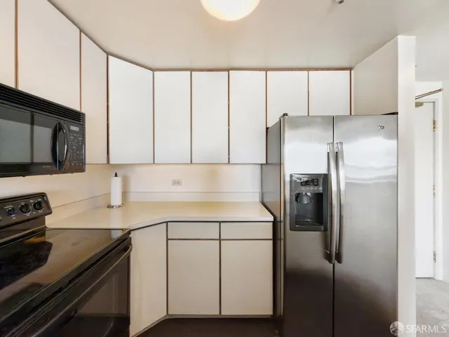 a kitchen with a refrigerator sink and cabinets