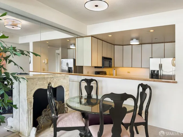 a kitchen with a table chairs refrigerator a sink and dishwasher with wooden floor