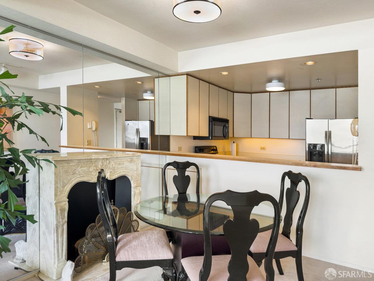 601 Van Ness Avenue, Unit 750 San Francisco, CA 94102 - Photo 21 of 37 a kitchen with a table chairs refrigerator a sink and dishwasher with wooden floor