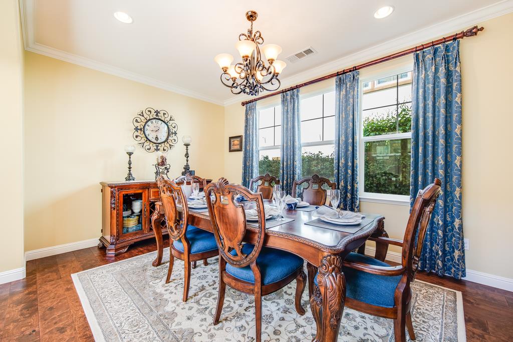 7670 MacKenzie Way Gilroy, CA 95020 - Photo 17 of 70 a dining room with wooden floor a chandelier a wooden table and chairs
