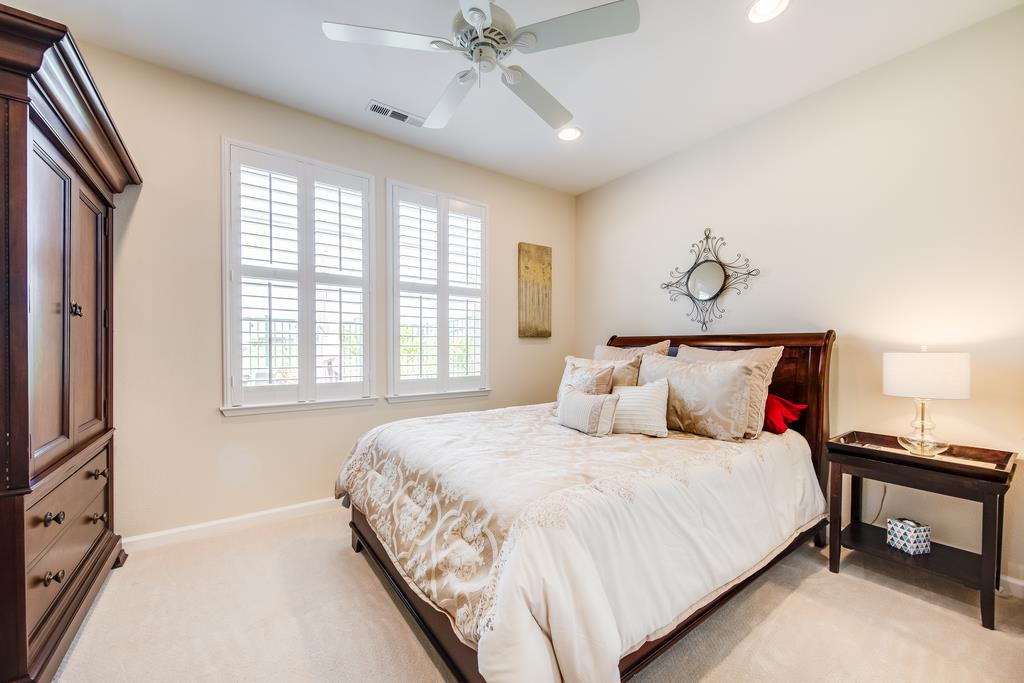 7670 MacKenzie Way Gilroy, CA 95020 - Photo 32 of 70 a bedroom with a large bed and a chandelier