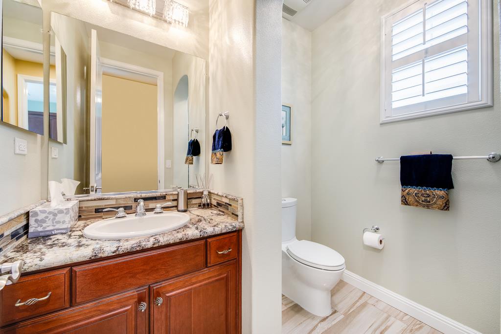 7670 MacKenzie Way Gilroy, CA 95020 - Photo 34 of 70 a bathroom with a granite countertop sink toilet and mirror
