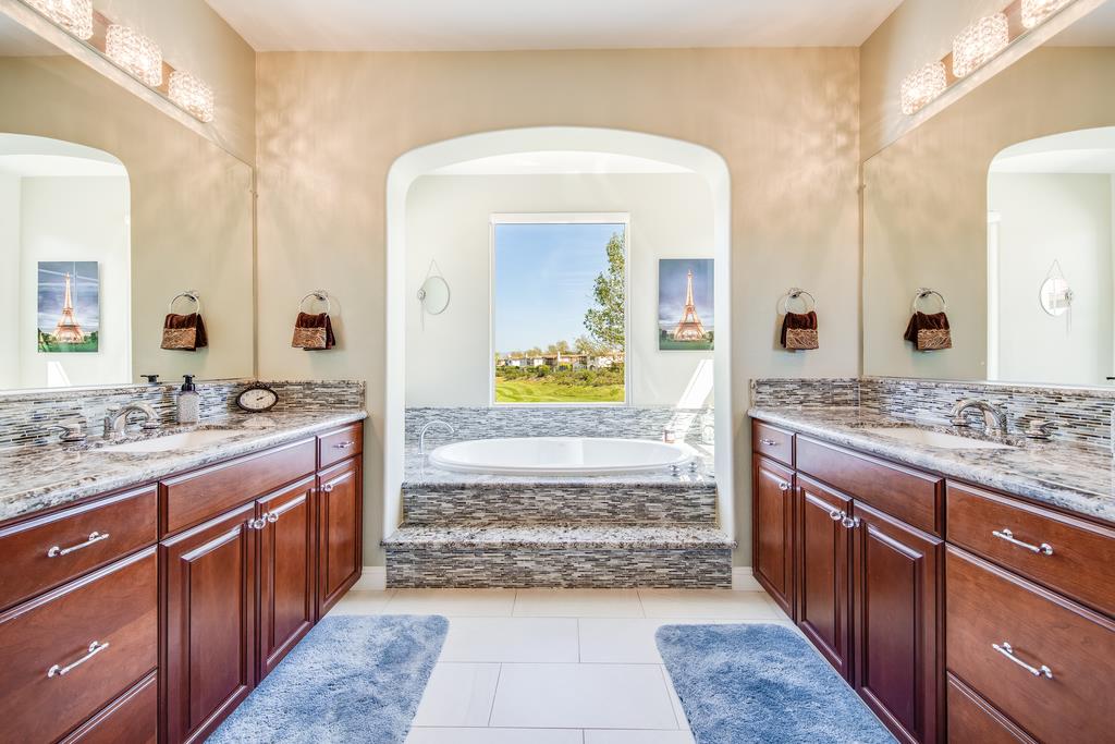 7670 MacKenzie Way Gilroy, CA 95020 - Photo 50 of 70 a bathroom with a granite countertop sink and a mirror