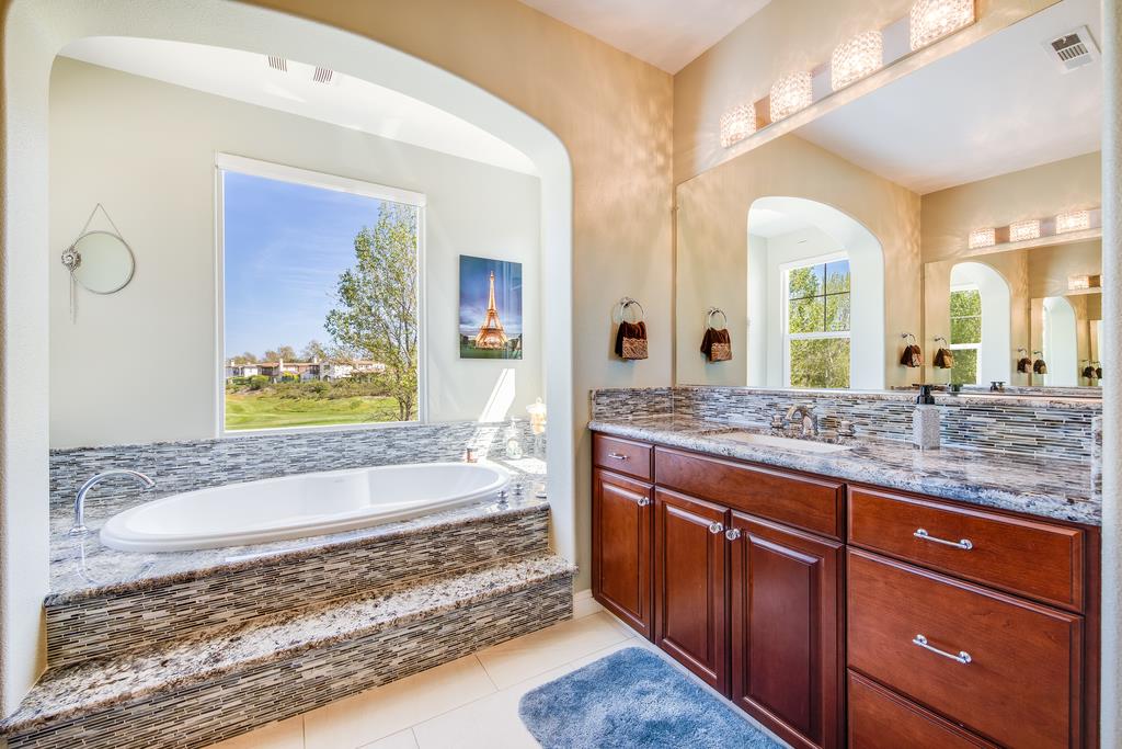 7670 MacKenzie Way Gilroy, CA 95020 - Photo 51 of 70 a spacious bathroom with a granite countertop sink and a mirror