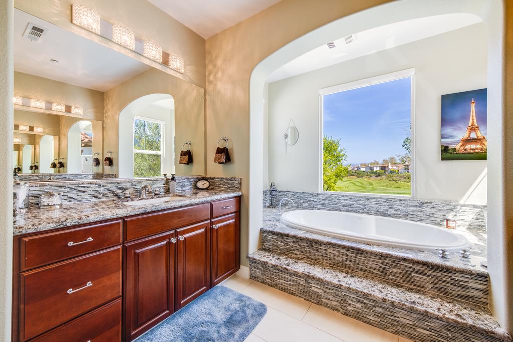 7670 MacKenzie Way Gilroy, CA 95020 - Photo 54 of 70 a spacious bathroom with a granite countertop sink and a mirror