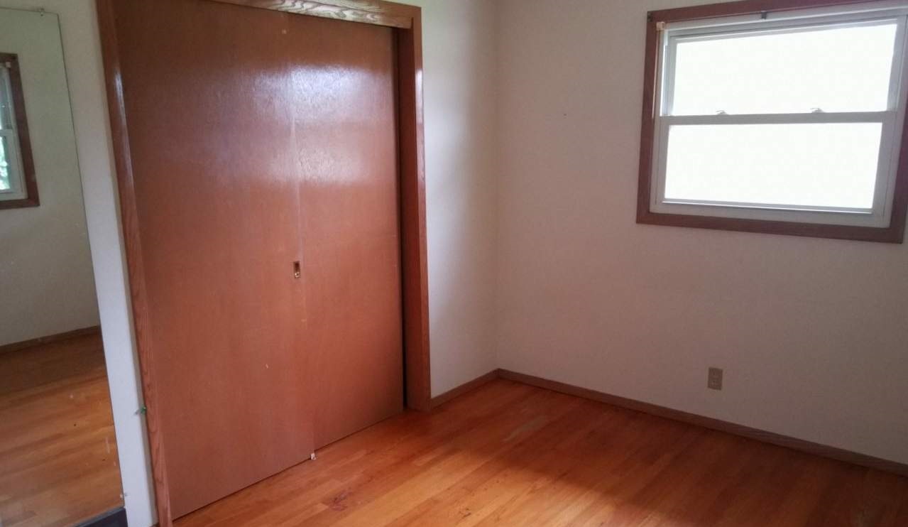 724 Windsor Road Loves Park, IL 61111 - Photo 8 of 11 an empty room with wooden floor and windows