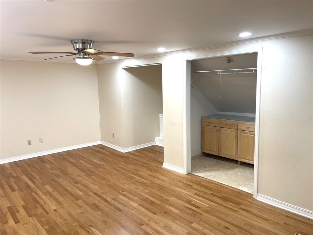 720 Coachlight Road Shreveport, LA 71106 - Photo 18 of 22 an empty room with wooden floor and cabinet