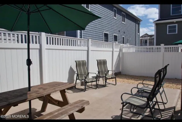 a view of a patio with table and chairs and umbrella