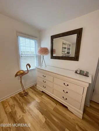 a room with painting on the wall and a dresser