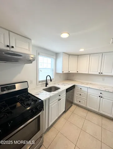 a kitchen with a stove sink and cabinets