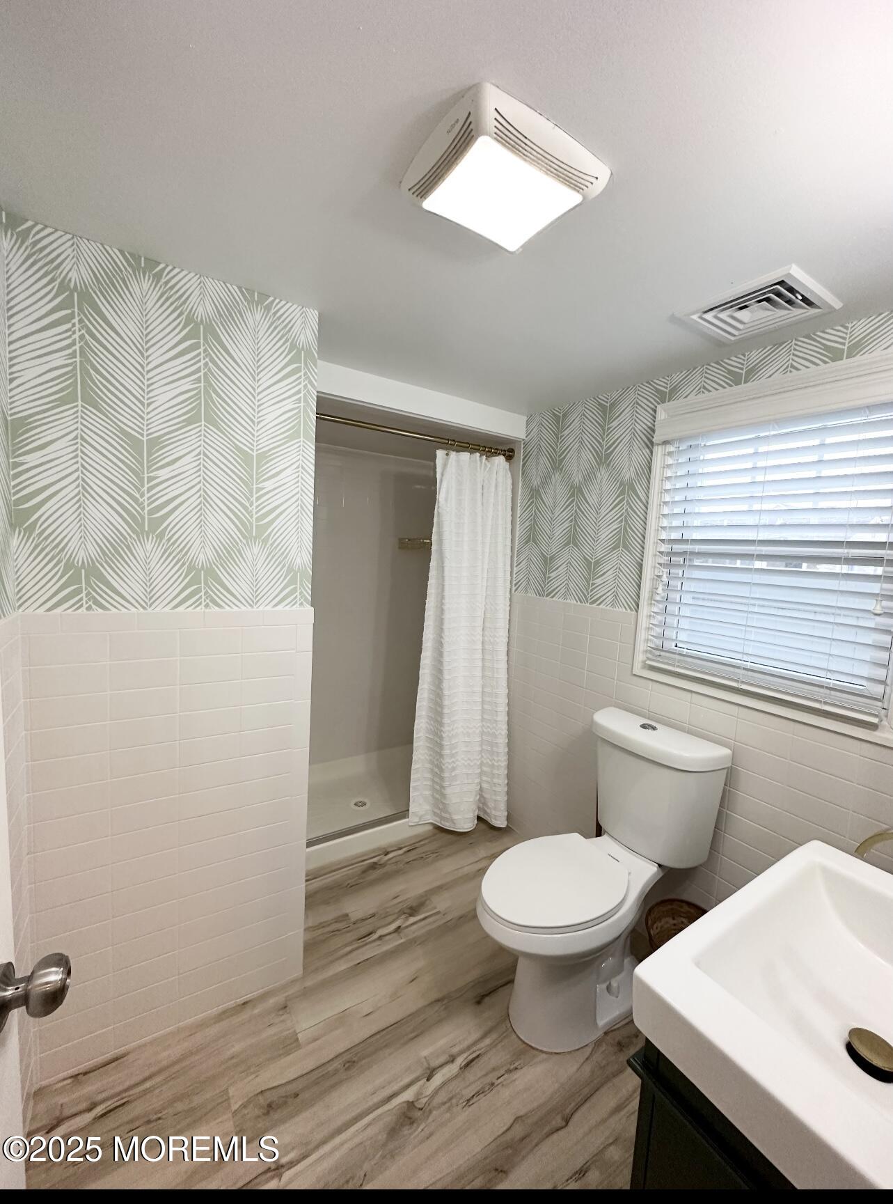 7 Princeton Avenue Lavallette, NJ 08735 - Photo 8 of 17 a white toilet sitting next to a bathroom sink and vanity