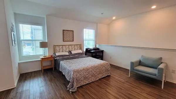 a bedroom with a bed and wooden floor