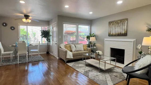 a living room with furniture a fireplace and a large window