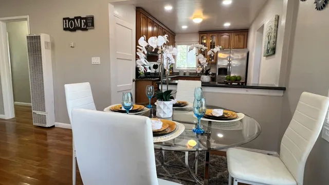 a dining room with furniture potted plants and wooden floor