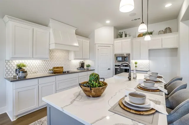 a kitchen with stainless steel appliances kitchen island granite countertop a sink and cabinets