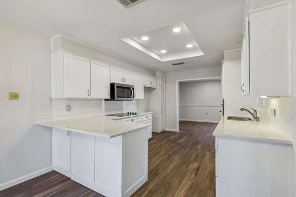 a kitchen with a sink a stove and cabinets