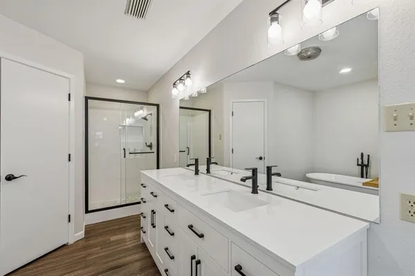 a bathroom with double vanity sink and a mirror