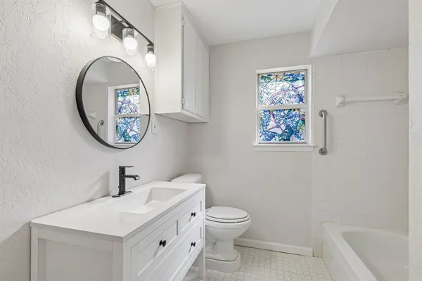 a bathroom with a toilet a sink and a mirror