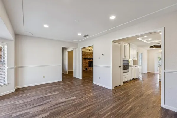a view of a big room with wooden floor and windows