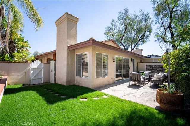 a view of a house with backyard sitting area and garden