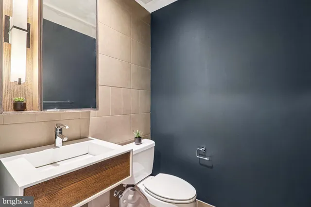 a bathroom with a sink a toilet and mirror