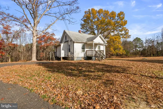 a front view of a house with a yard covered with snow