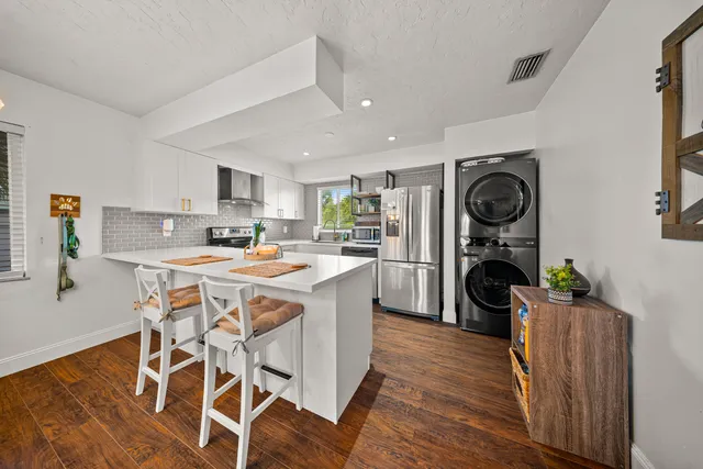 a kitchen with stainless steel appliances granite countertop a refrigerator and a stove top oven