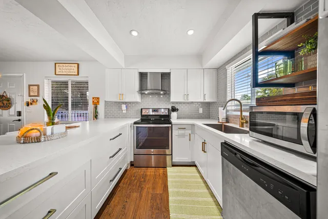 a kitchen with stainless steel appliances granite countertop a stove and a sink