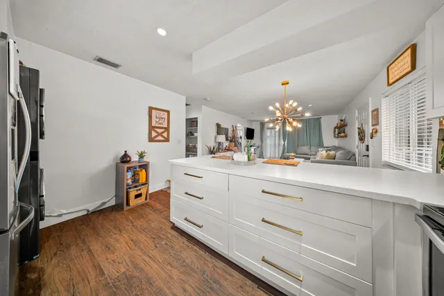 a spacious bedroom with a bed a dresser and flat screen tv