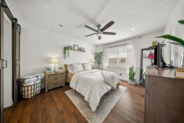 a spacious bedroom with a bed and a flat screen tv