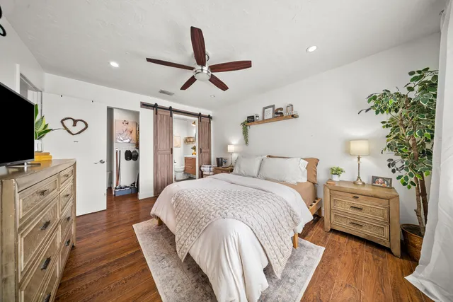 a spacious bedroom with a bed and a flat screen tv