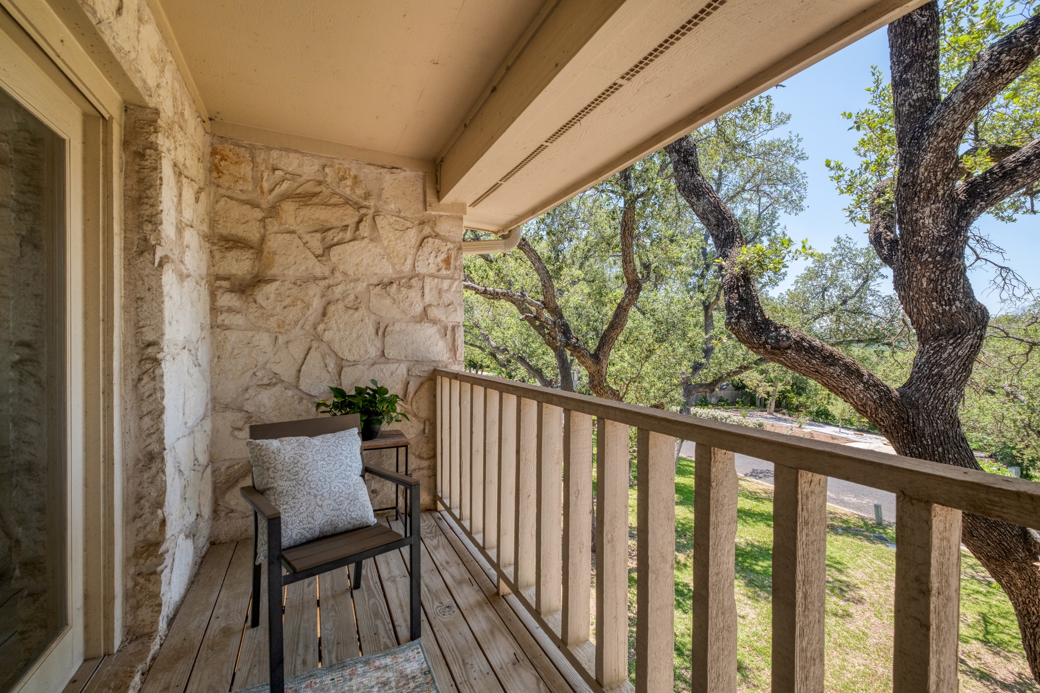 202 Ridgewood Drive Georgetown, TX 78628 - Photo 25 of 40 Private balcony featuring wood-finish flooring, stone-clad wall, and a wood railing overlooking mature trees