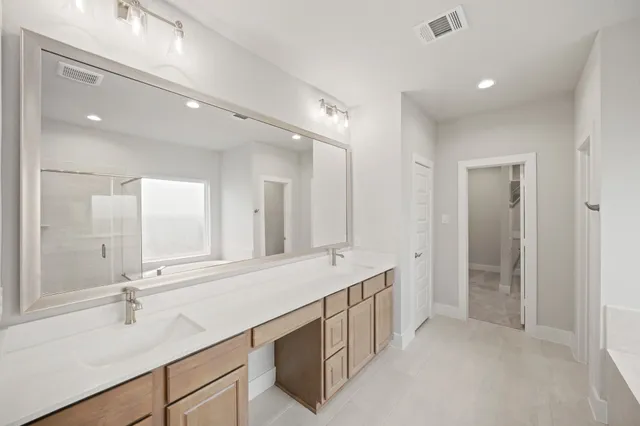 a bathroom with a double vanity sink mirror and