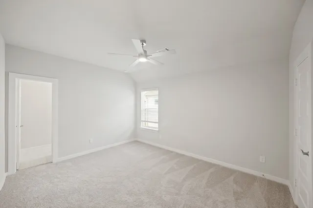 an empty room with a window and ceiling fan