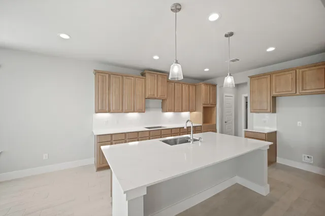 a kitchen with a sink a refrigerator and white cabinets