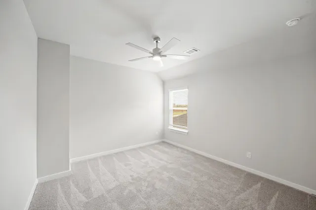 an empty room with a window and a ceiling fan