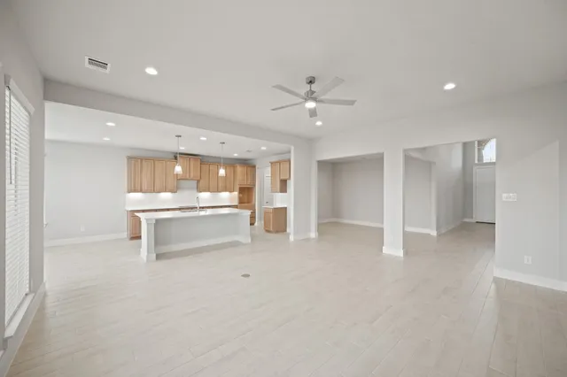 a view of an empty room with a kitchen