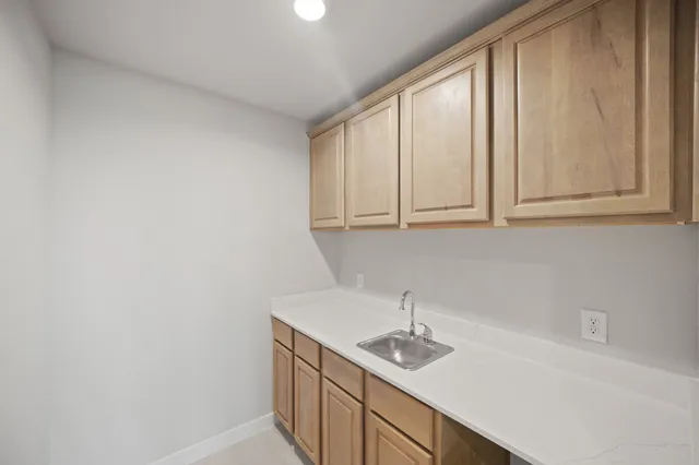 a kitchen with a sink cabinets and a window