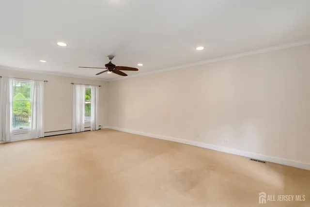 an empty room with windows and fan
