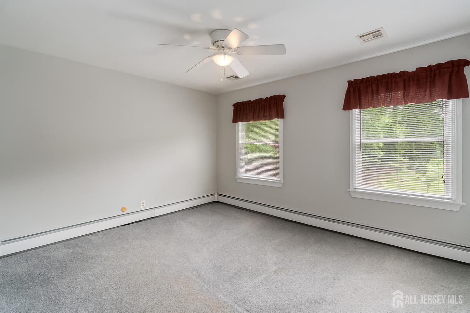 526 County Road, Unit 579 Ringoes, NJ 08551 - Photo 46 of 51 an empty room with windows and chandelier fan