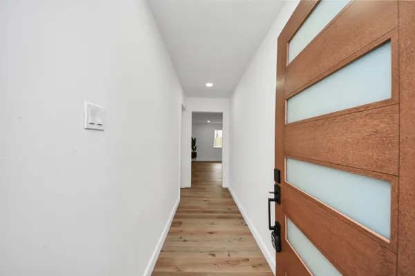a view of a hallway with wooden floor and staircase