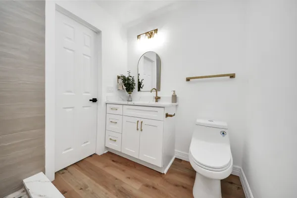 a bathroom with a toilet sink and mirror