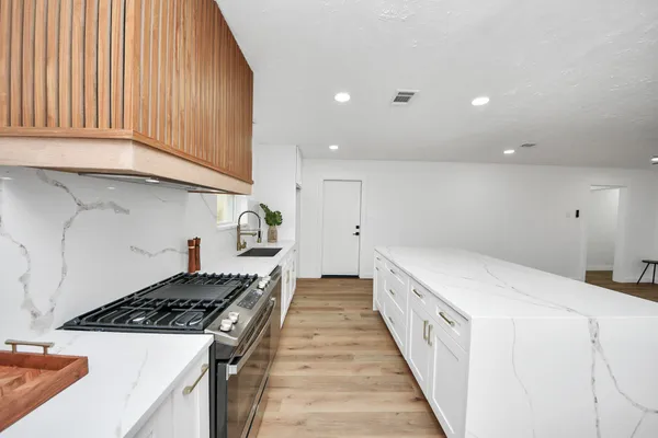 a kitchen with a stove and white cabinets
