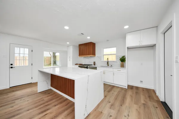 a kitchen with white cabinets and sink