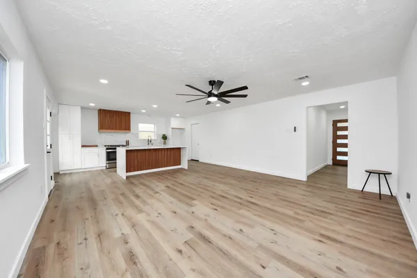 a view of a kitchen with wooden floor and a ceiling fan