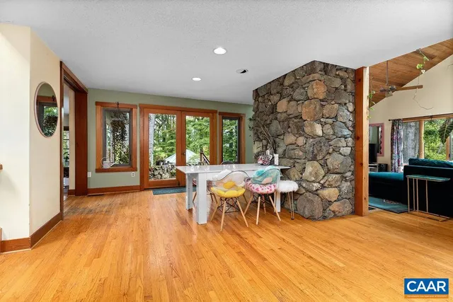 a living room with furniture a rug and a floor to ceiling window